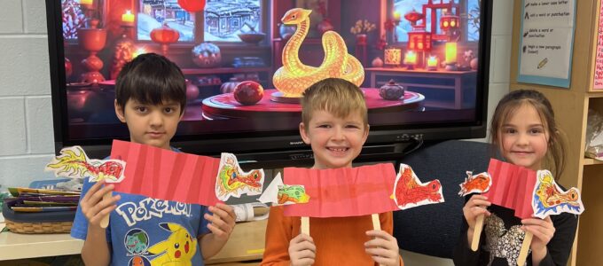 Three students with paper lanterns and paper dragon