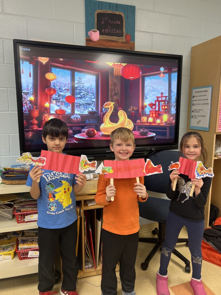 Three students with paper lanterns and paper dragon